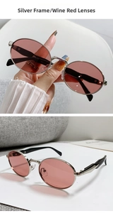 Nahaufnahme der Vintage-Oval-Sonnenbrille mit silbernem Metallrahmen und weinroten Gläsern