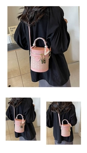 Detailed back view of pink cylinder bucket bag with woven texture and silk scarf handle