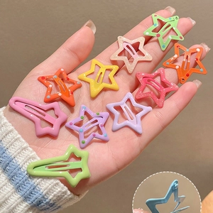 Colorful Y2K star-shaped hair clips with glitter and polka dots held in hand