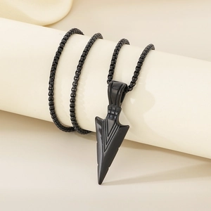 Close-up of hip hop black stainless steel arrow pendant on a sleek metal chain necklace