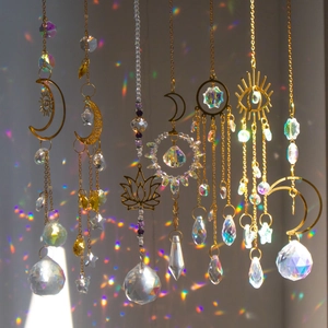 K9 crystal suncatcher with moon and lotus metal designs casting rainbow light reflections