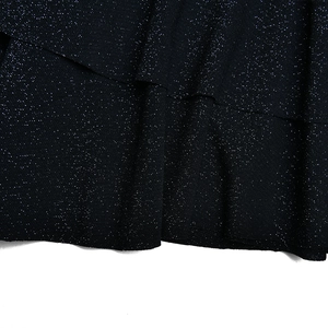 Gros plan sur le tissu pailleté noir brillant de la mini robe sexy à col en V