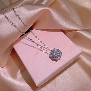 Elegant silver necklace set with brilliant-cut zircon pendant on pink silk display
