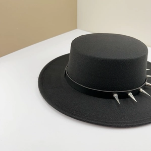 Detailed side view of a black wool punk hat featuring sharp silver metallic spikes