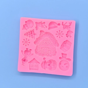 Pink silicone mold for Christmas cakes featuring house, snowman, and reindeer shapes