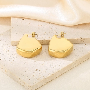 Détail des boucles d'oreilles irrégulières plaquées or 18K sur pierre de travertin