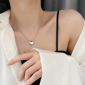 Minimalist silver heart pendant necklace on model with elegant stainless steel chain
