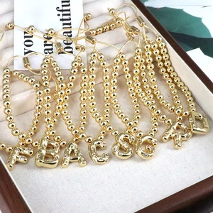 Gold beaded bracelet with sparkling zircon initial charms and adjustable sliding cord