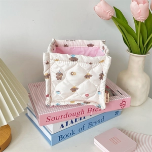 Detalle de cesta de tela acolchada con estampados de perros y forro interior rosa