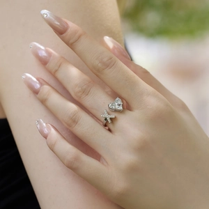 Detail of S925 sterling silver adjustable ring with heart zircon and cross on model