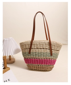 Détail du sac cabas en paille tissée avec rayures colorées et bandoulières en cuir marron