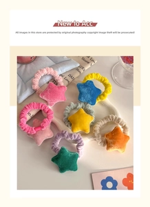 Close-up of velvet star hair scrunchies in eight candy colors on a white ceramic plate
