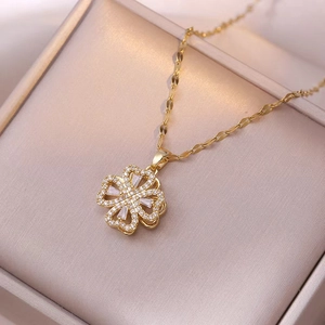 Elegant gold spinning clover necklace with sparkling white crystals and fine water wave chain