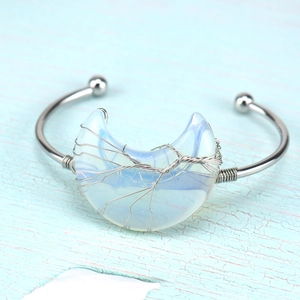 Detail of silver wire-wrapped tree of life bangle with iridescent crescent moon stone