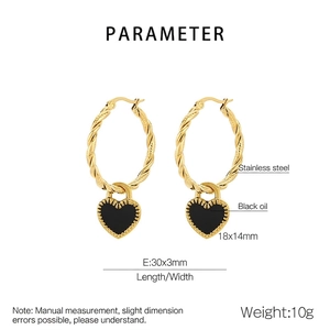 Détail macro d'un anneau torsadé plaqué or 18K avec pendentif cœur noir en émail poli