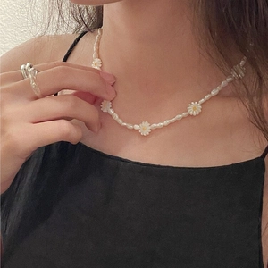 French style daisy pearl necklace with white petal flowers and a silver twisted ring