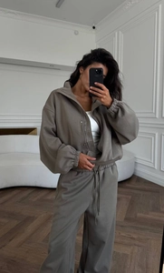Détail d'un ensemble de survêtement gris deux pièces avec sweat zippé et cordon de serrage