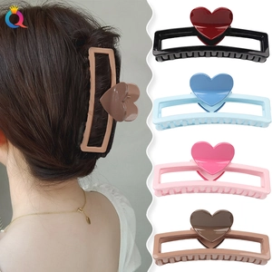 Square claw clips with heart detail in black, blue, pink, and brown displayed on model
