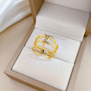 Three-layer adjustable gold lucky clover ring presented in a beige jewelry display box