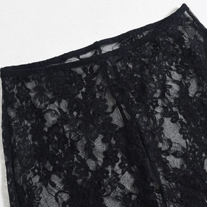 Vista macro de bordado de encaje floral negro y malla transparente en el top
