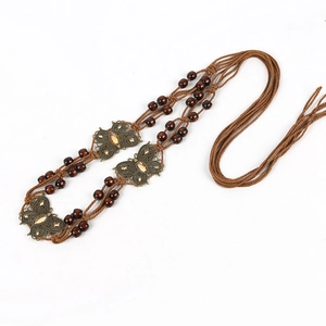 Detail of hand-woven brown rope belt with bronze butterflies and amber gemstones