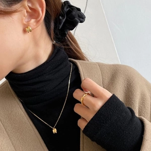 Minimalist gold jewelry set with ring necklace and earrings on model in autumn style