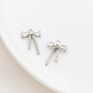 Macro detail of silver bow pendant with cubic zirconia inlay for DIY jewelry design