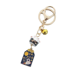 Japanese lucky cat keychain with astronaut theme, golden bell, and fortune charms