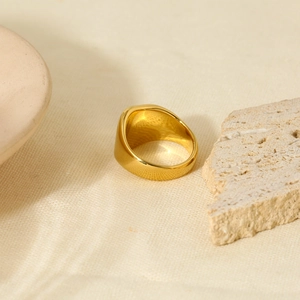 Detailed view of gold plated 316L stainless steel ring with hammered texture on fabric