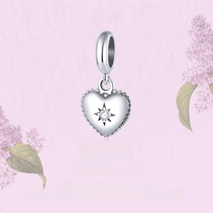 Macro view of S925 sterling silver heart charm with starburst zircon and beaded texture