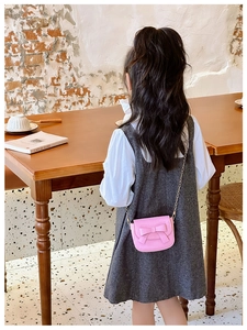 Pink mini crossbody bag for girls with bow decoration and gold chain strap on child model