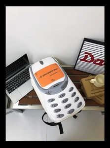 Detail view of a creative mobile phone shaped backpack with vintage keypad design