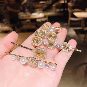 Close-up of vintage champagne crystals and pearls set in light gold alloy hair clips
