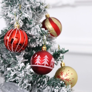 Detail of red and gold Christmas ornaments hanging on a snowy tree branch