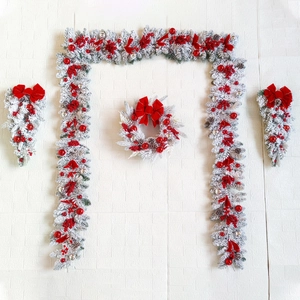 Detail of flocked Christmas wreaths with red bows, berries and silver ornaments set