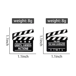 Detail view of film clapperboard enamel pins with dimensions and weight measurements