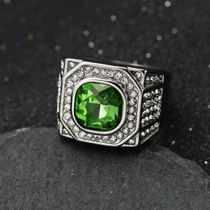 Macro shot of silver signet ring with large green square stone and white pavé crystals