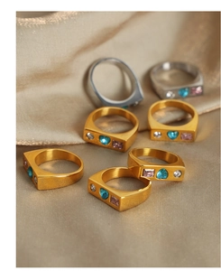 Detailed macro view of colorful zircon stones set in square gold and silver geometric rings