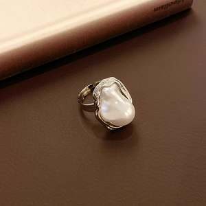 Detailed macro view of baroque pearl ring with irregular silver lava texture on leather