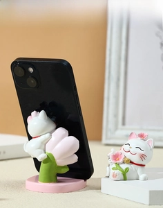 Macro detail of Lucky Cat resin phone stand with cherry blossom base and phone slot