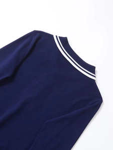 Détail du polo en maille bleu marine avec des rayures contrastées blanches sur le col