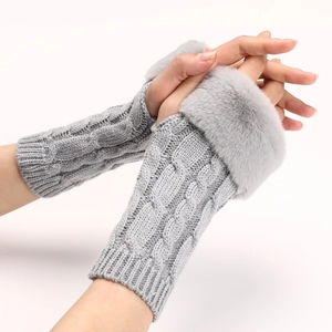 Detail of grey cable knit fingerless gloves with soft faux fur trim for winter warmth