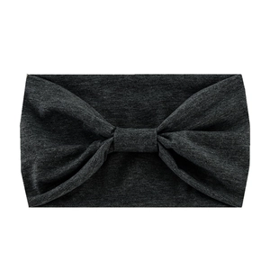 Close-up of a dark grey knitted yoga headband with a decorative bow knot detail