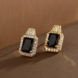 Macro view of gold-plated square black zircon earrings with sparkling halo detail