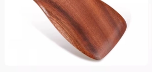 Detail showing the narrow back design and natural dark wood grain of the ebony spatula