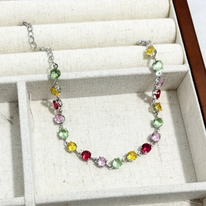 Detailed macro view of colorful round-cut gemstones on a silver chain bracelet