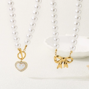 Close-up of pearl necklaces with a crystal heart pendant and golden bow detail