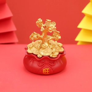 Golden money tree figurine on red fortune bag base with festive origami background