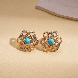 Detailed macro of gold flower stud earrings with turquoise beads and crystal petals