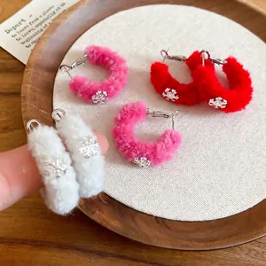 Winter velvet hoop earrings with metal snowflake charms in white, pink, and red colors